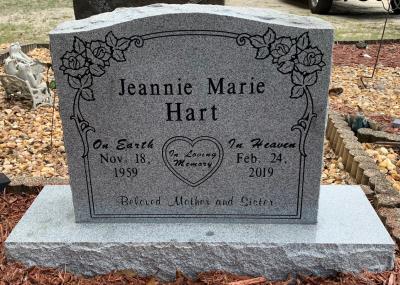 individual upright granite headstone with floral design and heart emblem